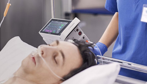 (opens in a pop-up) a man lying on a bed with a medical device